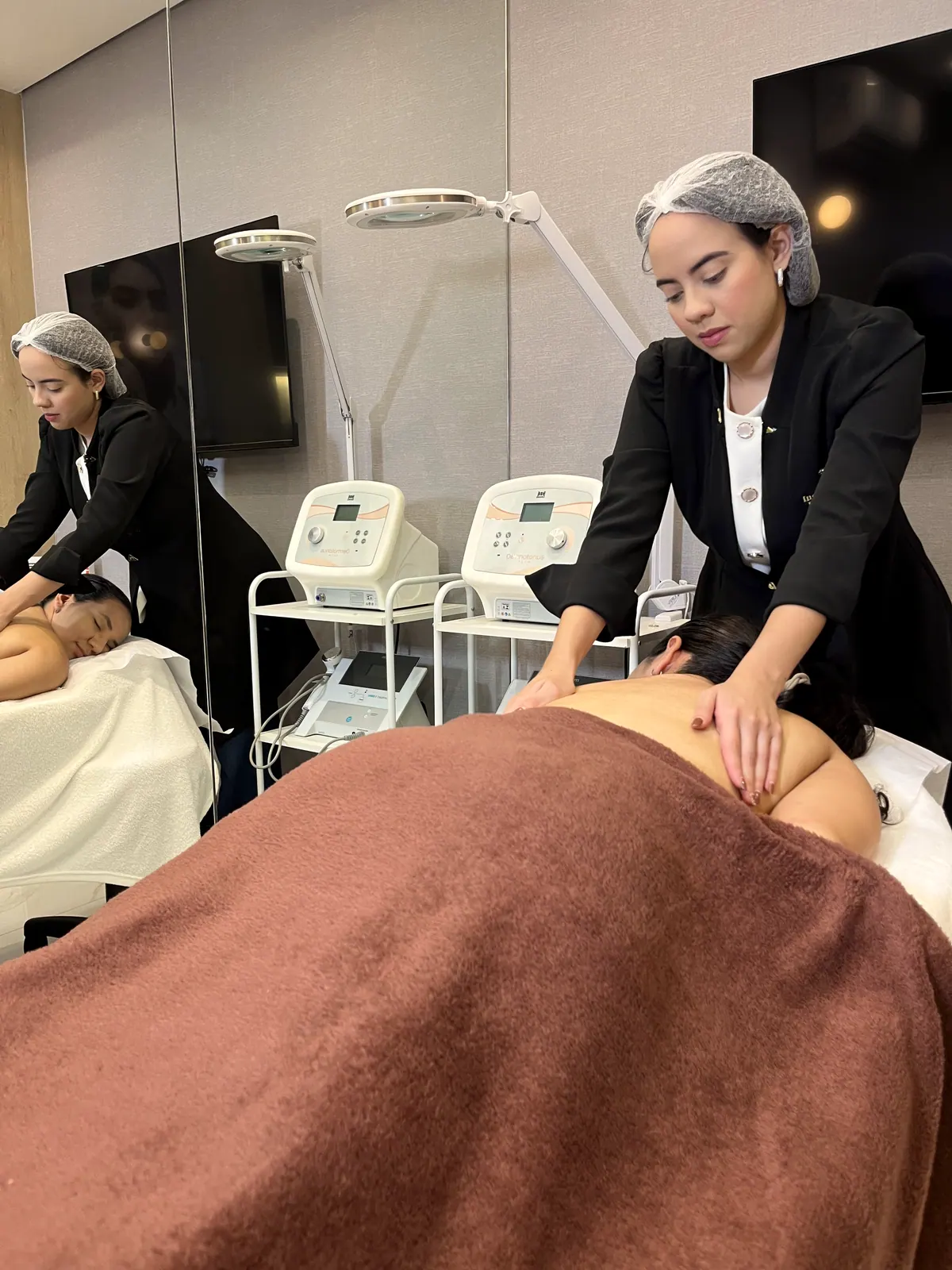 Duas esteticistas atendendo na sala de estética corporal