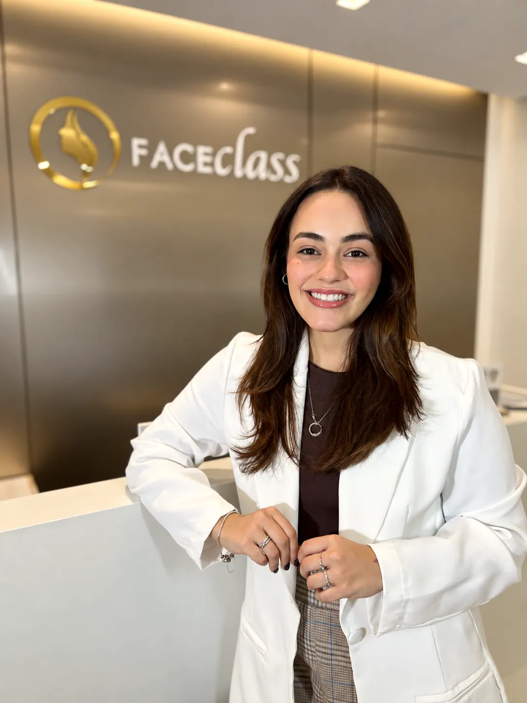 Dra. Náthalie Sophie sorrindo diante do logo dourado da Faceclass